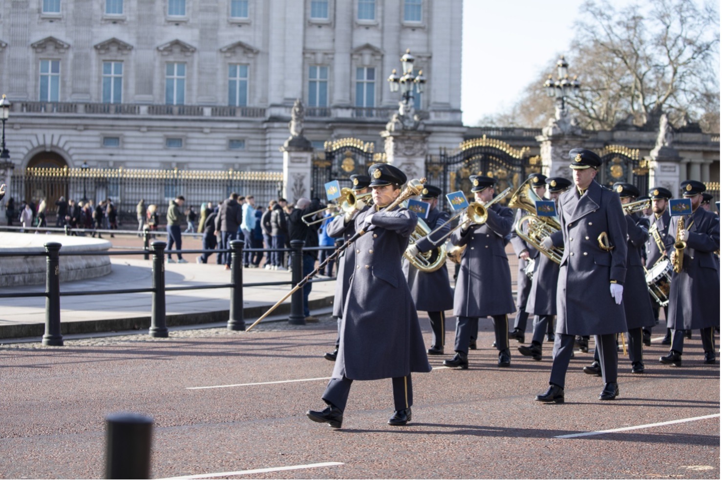The Band play brass instruments in front of Buckingham Palace.
